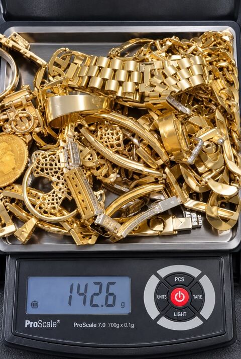 Yellow gold chains and rings being weighed on Marty’s scale